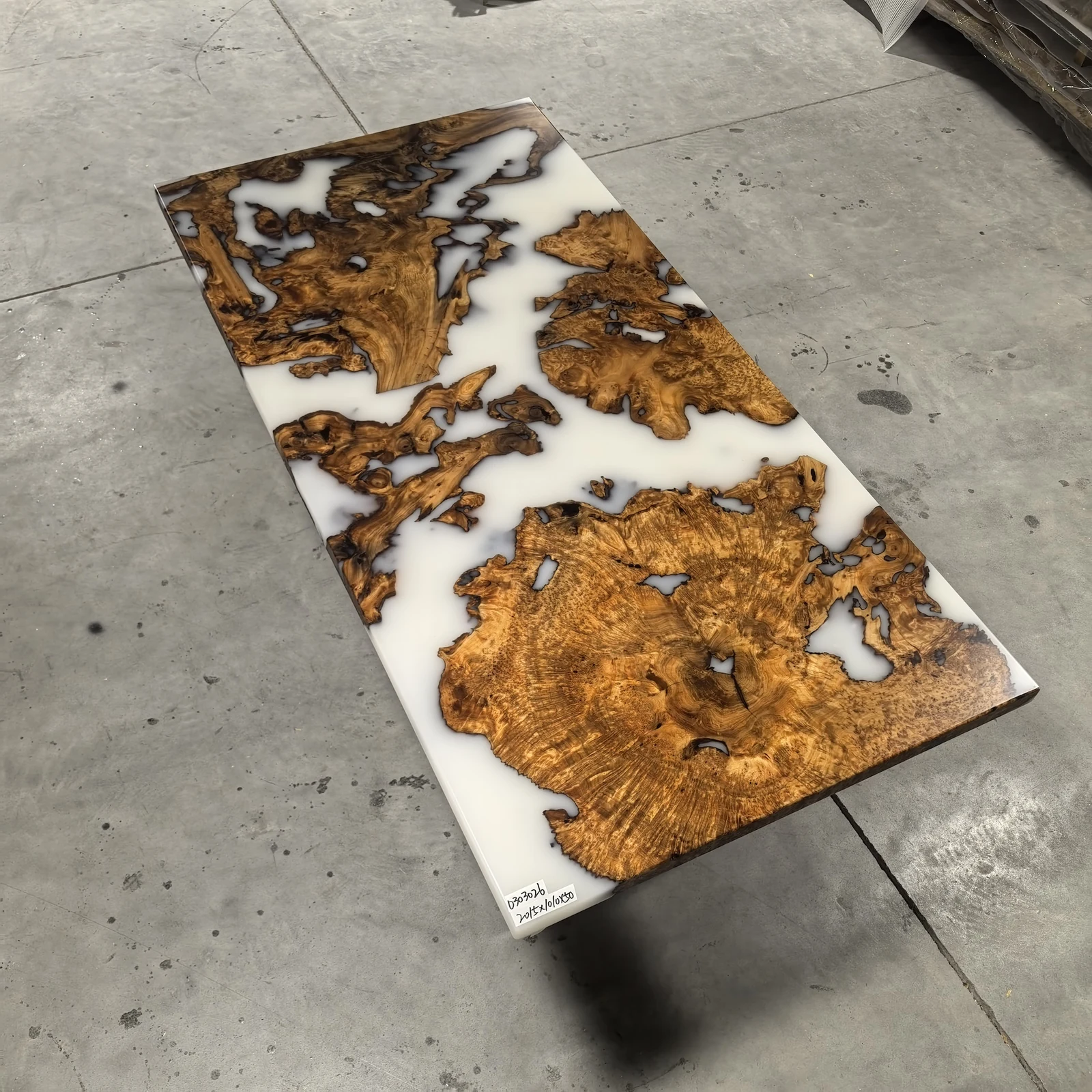 Angled full view of ET0001 wood epoxy table top with white resin and irregular wood sections