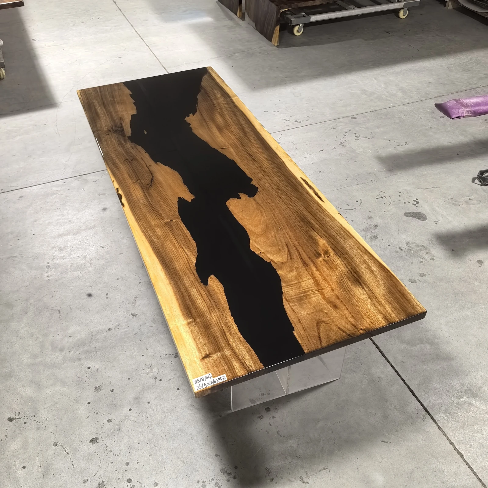 Angled full view of ET0002 wood epoxy table top with a broad black resin river