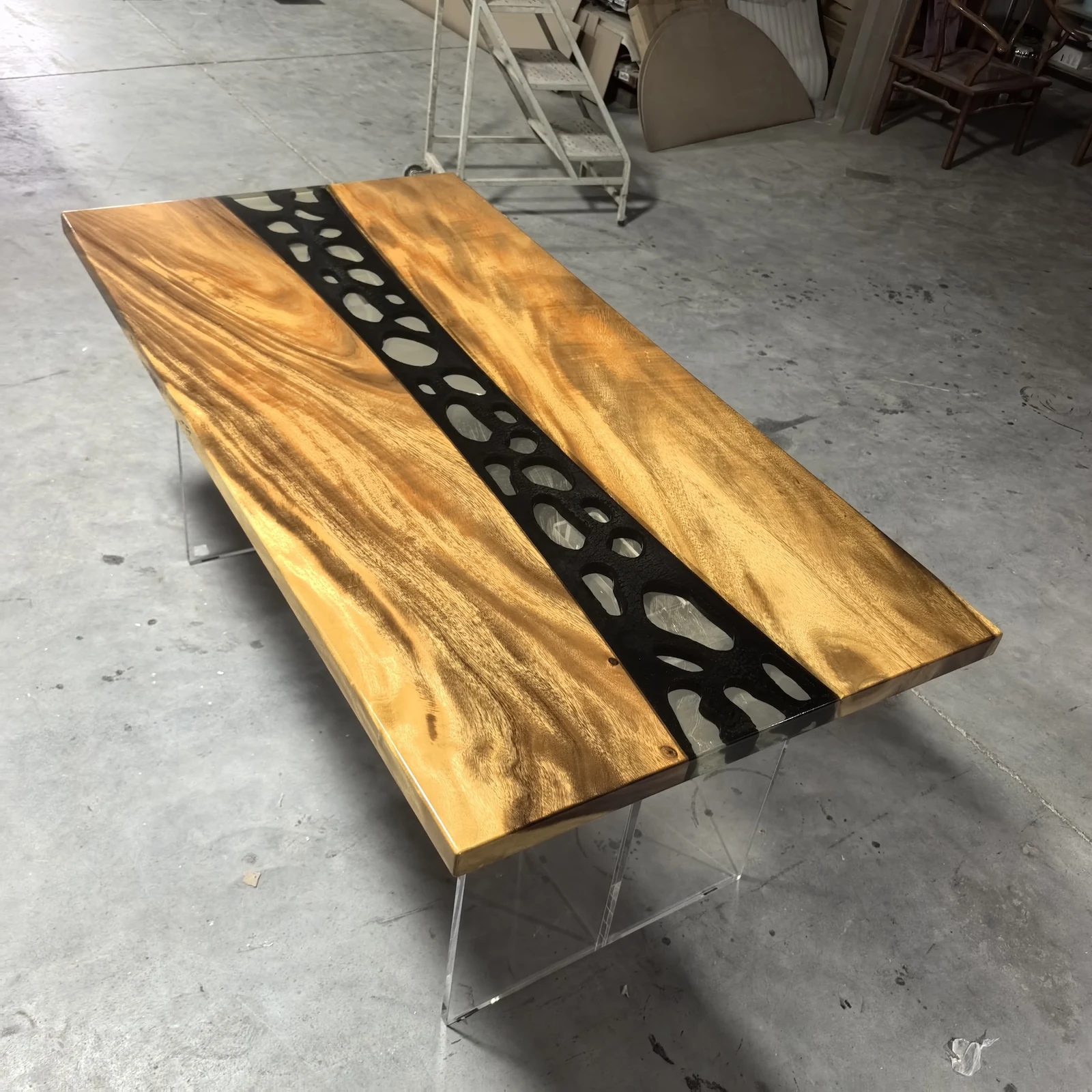 Angled full view of ET0003 wood epoxy table top with a black channel and light decorative inlays